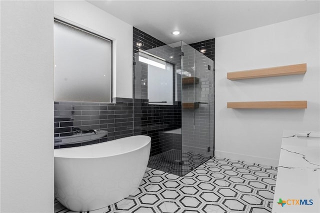 bathroom featuring separate shower and tub and tile walls