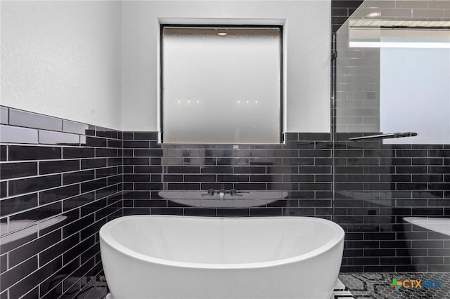 bathroom featuring tile walls and a bath