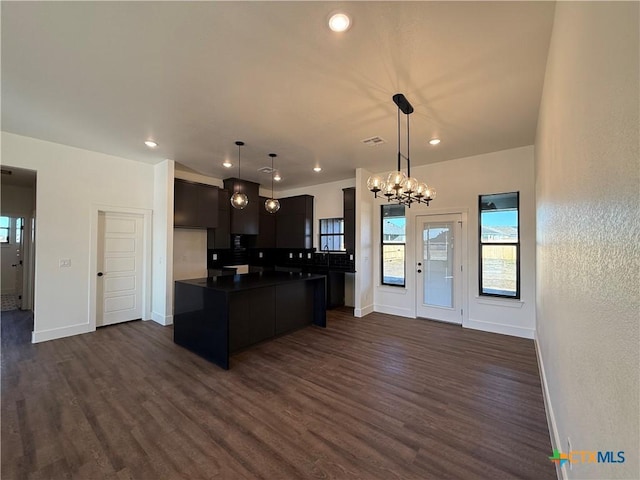 kitchen with dark hardwood / wood-style flooring, decorative light fixtures, a center island, and an inviting chandelier