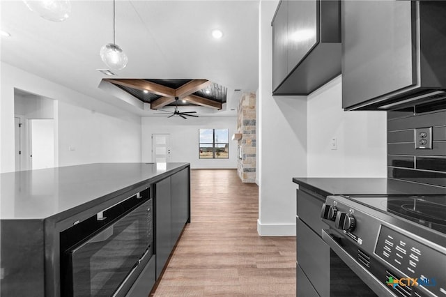 kitchen with black microwave, hanging light fixtures, light hardwood / wood-style flooring, ceiling fan, and electric range