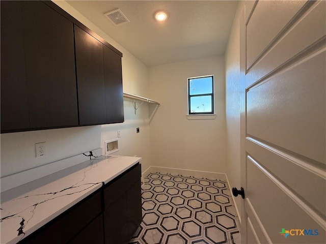 laundry room with cabinets, hookup for a washing machine, hookup for an electric dryer, and light tile patterned floors