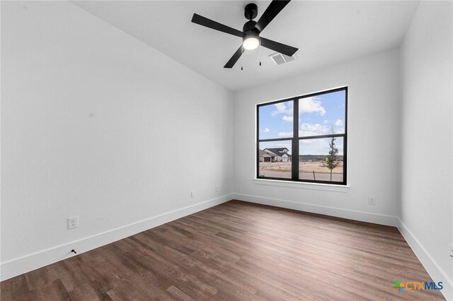 unfurnished living room with a stone fireplace, dark wood-type flooring, beamed ceiling, and ceiling fan with notable chandelier