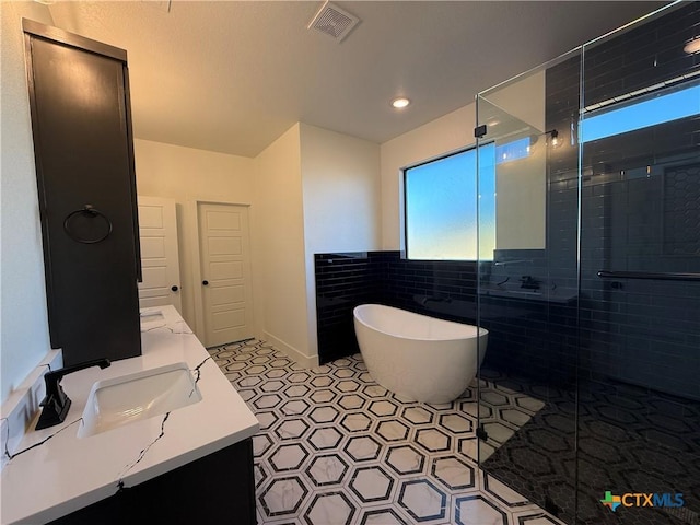 bathroom featuring tile patterned floors, vanity, and shower with separate bathtub