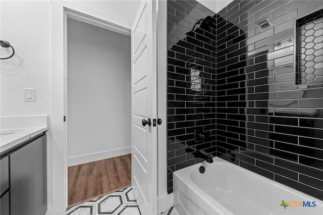 bathroom featuring hardwood / wood-style floors, tiled shower / bath, and vanity