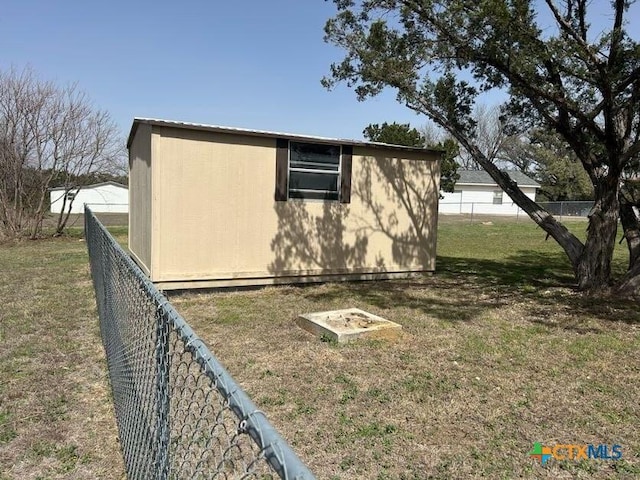 view of property exterior with an outbuilding, a yard, a storage unit, and fence