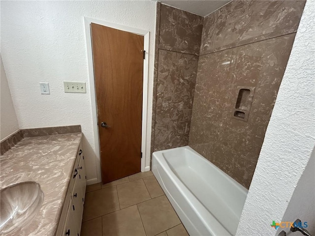 full bathroom featuring tub / shower combination, a textured wall, vanity, and tile patterned floors