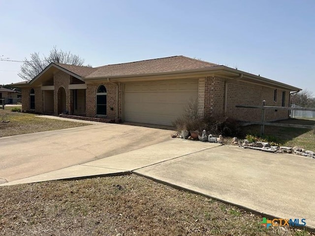 ranch-style home with a garage, driveway, and brick siding