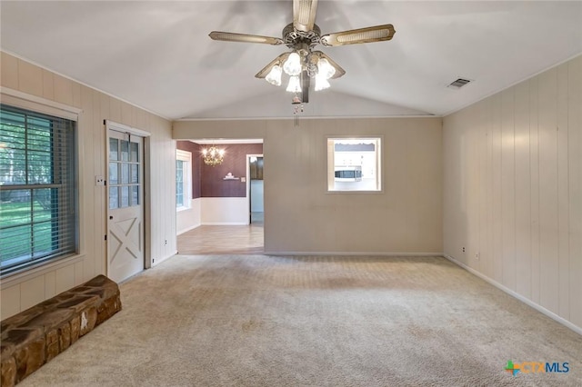 304 Simpson Rd, Victoria, TX 77904 - empty room featuring a chandelier, carpet floors, plenty of natural light, lofted ceiling, and wooden walls