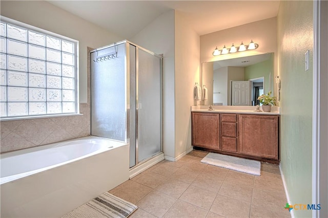 bathroom featuring double vanity, a stall shower, a sink, and tile patterned floors