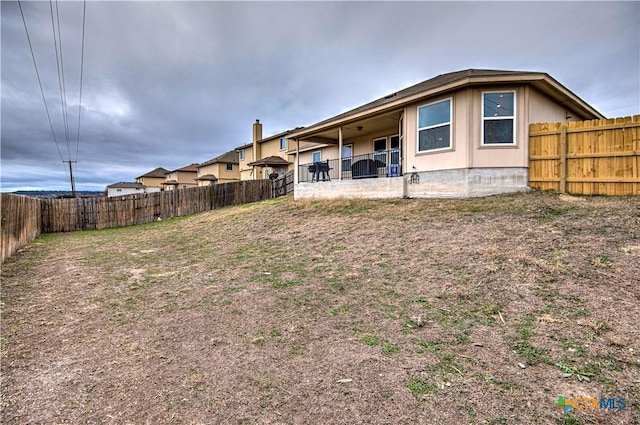 rear view of house with a fenced backyard