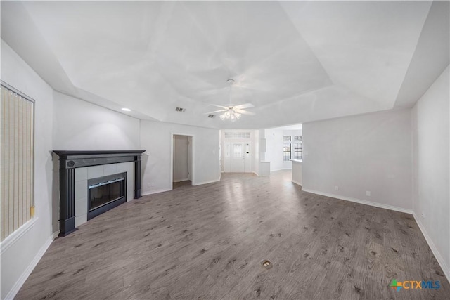 607 Topaz Ave, Seguin, TX 78155 - unfurnished living room featuring a tray ceiling, a tile fireplace, ceiling fan, wood finished floors, and recessed lighting