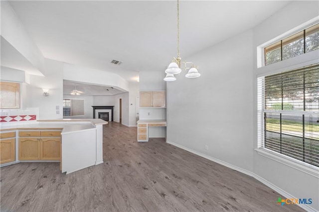 607 Topaz Ave, Seguin, TX 78155 - kitchen with light brown cabinets, open floor plan, a fireplace, light wood-style flooring, and a chandelier