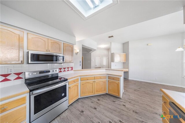 607 Topaz Ave, Seguin, TX 78155 - kitchen featuring stainless steel appliances, light brown cabinets, light countertops, and light wood-style floors