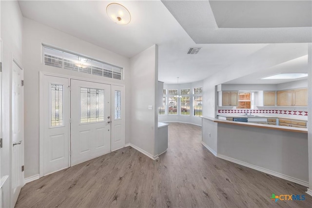 foyer entrance featuring sink and light hardwood / wood-style flooring