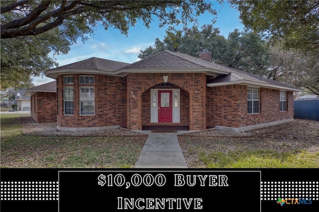 607 Topaz Ave, Seguin, TX 78155 - view of front of home with brick siding, a chimney, and a shingled roof