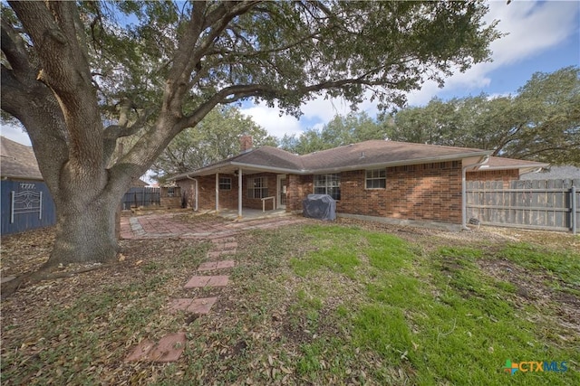 607 Topaz Ave, Seguin, TX 78155 - rear view of property with a chimney, brick siding, and a patio