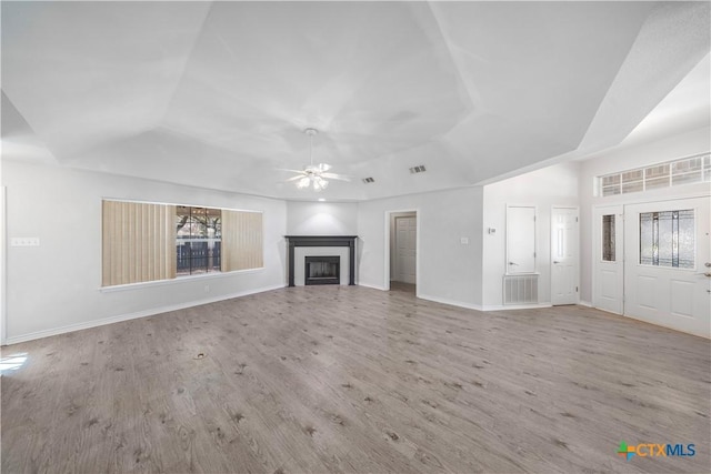 607 Topaz Ave, Seguin, TX 78155 - unfurnished living room featuring a raised ceiling, a ceiling fan, a fireplace, wood finished floors, and baseboards