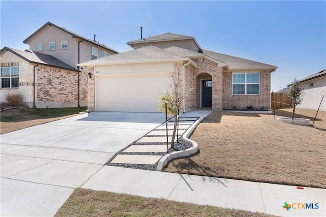 view of front of property with brick siding, driveway, an attached garage, and fence