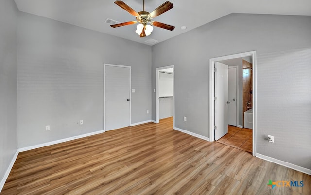 unfurnished bedroom with ceiling fan, lofted ceiling, light hardwood / wood-style floors, and ensuite bath