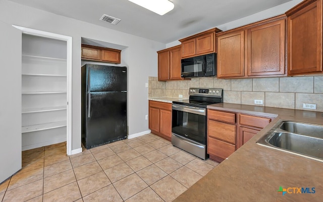 kitchen with sink, light tile patterned floors, black appliances, and decorative backsplash