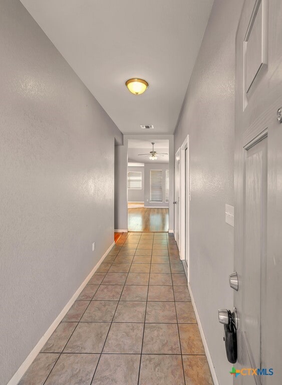 corridor featuring light tile patterned floors