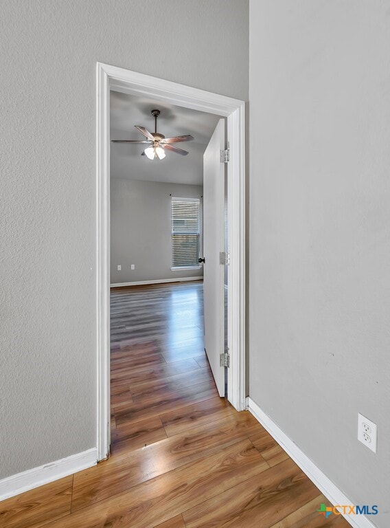 corridor with hardwood / wood-style flooring