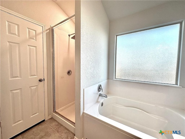 bathroom with independent shower and bath and tile patterned flooring