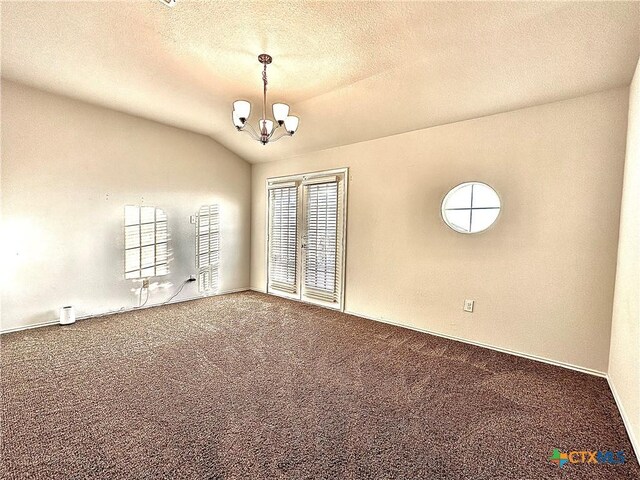 empty room with lofted ceiling, carpet floors, a notable chandelier, a textured ceiling, and french doors