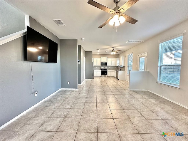 unfurnished living room with ceiling fan and light tile patterned floors