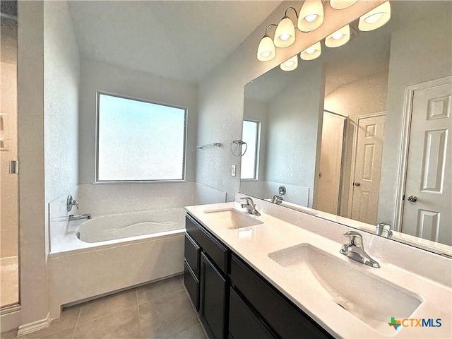 bathroom featuring a bathtub, vanity, and tile patterned flooring