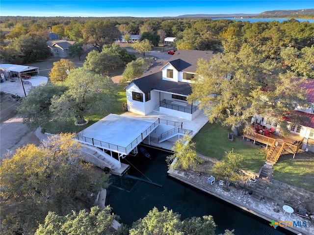 drone / aerial view with a forest view and a water view