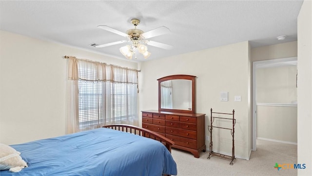 bedroom featuring baseboards, carpet flooring, visible vents, and a ceiling fan