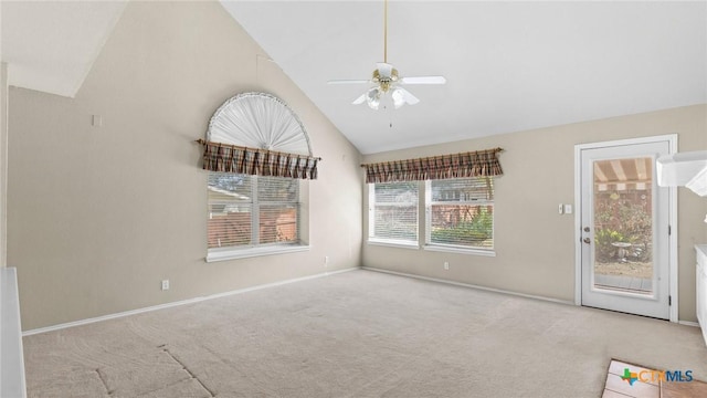 carpeted spare room with high vaulted ceiling, baseboards, and ceiling fan