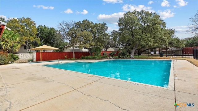 community pool with fence and a patio