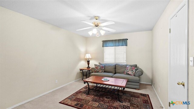 living area with carpet floors, baseboards, and a ceiling fan