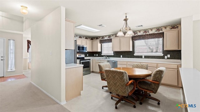 kitchen featuring appliances with stainless steel finishes, visible vents, a sink, and backsplash