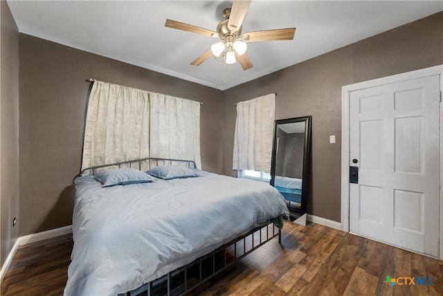 bedroom featuring ceiling fan, baseboards, and wood finished floors