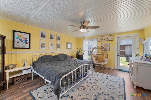 bedroom featuring access to exterior, wood finished floors, and ceiling fan