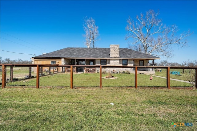 rear view of house with a yard and fence