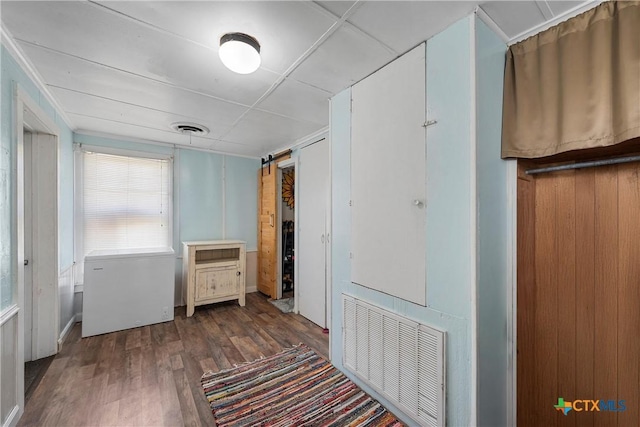 hallway featuring visible vents and wood finished floors