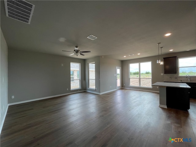 unfurnished living room with ceiling fan, dark hardwood / wood-style floors, and sink