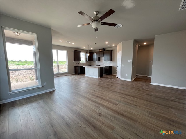 unfurnished living room with dark wood-type flooring and ceiling fan