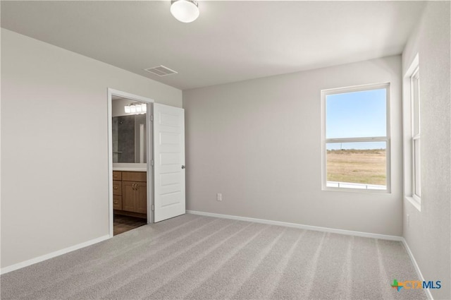 192 Lavender Ln, Elgin, TX 78621 - unfurnished bedroom with visible vents, connected bathroom, baseboards, and carpet floors