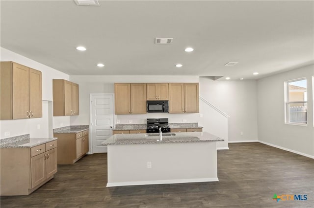 192 Lavender Ln, Elgin, TX 78621 - kitchen with dark wood-style flooring, visible vents, an island with sink, and black appliances