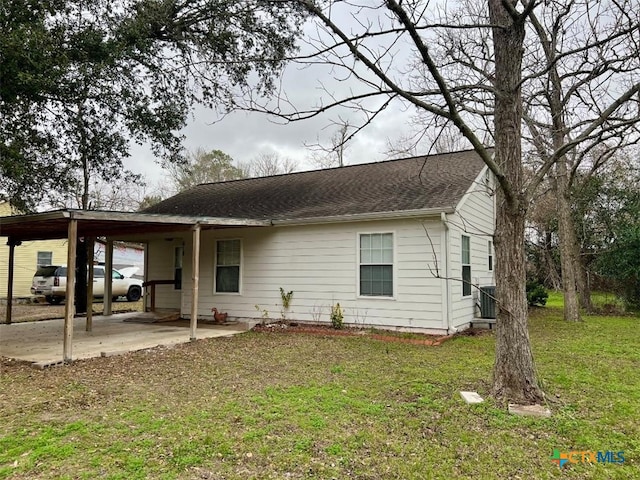 back of house featuring a yard, a carport, and central air condition unit