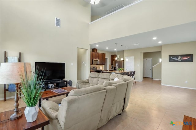 living room featuring light tile patterned floors and a towering ceiling