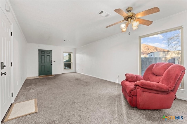 sitting room featuring ornamental molding, ceiling fan, and carpet