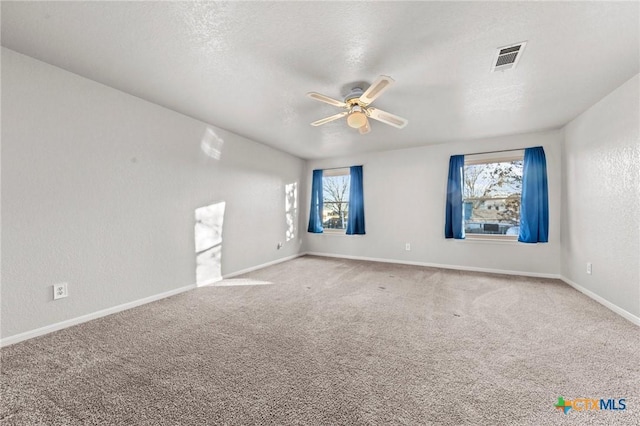 empty room with ceiling fan, a healthy amount of sunlight, and carpet flooring