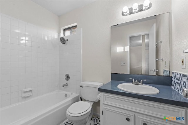 full bathroom featuring tiled shower / bath, vanity, and toilet