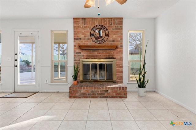 living room featuring a wealth of natural light, a brick fireplace, and light tile patterned floors